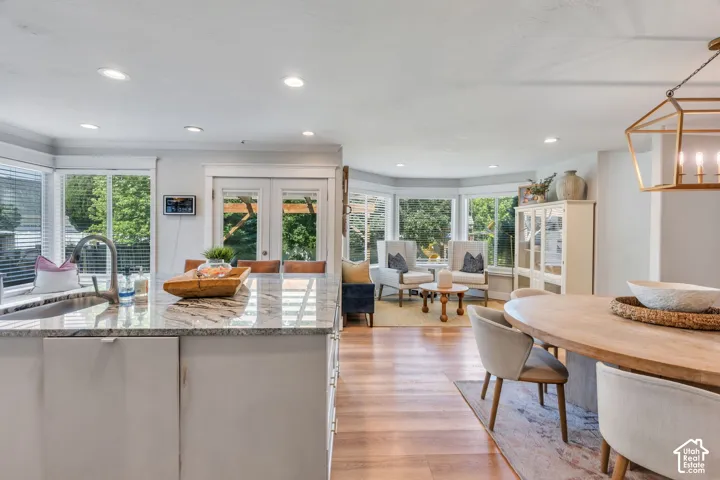 Kitchen island with a light-toned countertop, sink, and an integrated faucet