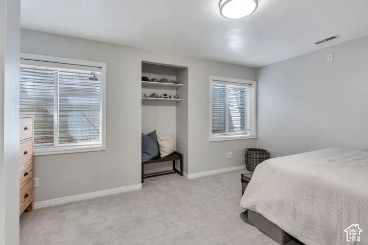 Carpeted room featuring a built-in bench with shelving, two windows, and a flush-mount ceiling light fixture