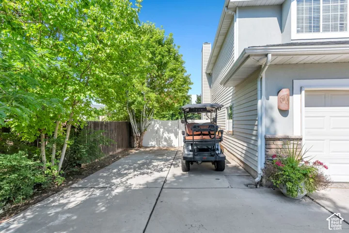 Concrete driveway leading to a garage with paneled doors and stone accents
