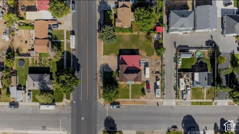 Corner lot property featuring a red-roofed residence, extensive paved street frontage, and a surrounding neighborhood context