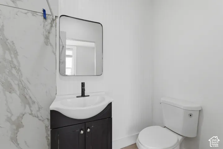 Modern bathroom vanity featuring a black cabinet, white countertop with integrated sink, and matte black faucet