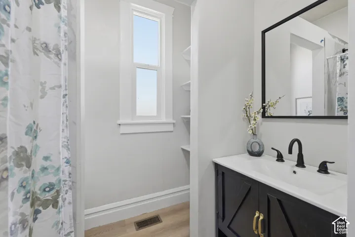 Bathroom featuring a black vanity with a white countertop, inset sink, and matte black faucet