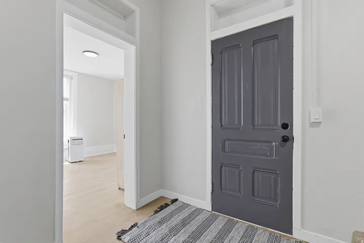 Panel door with dark finish, white trim, and light wall tones