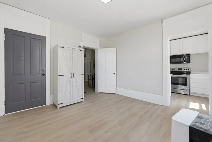 Light wood-finish flooring throughout, complemented by light grey wall paint