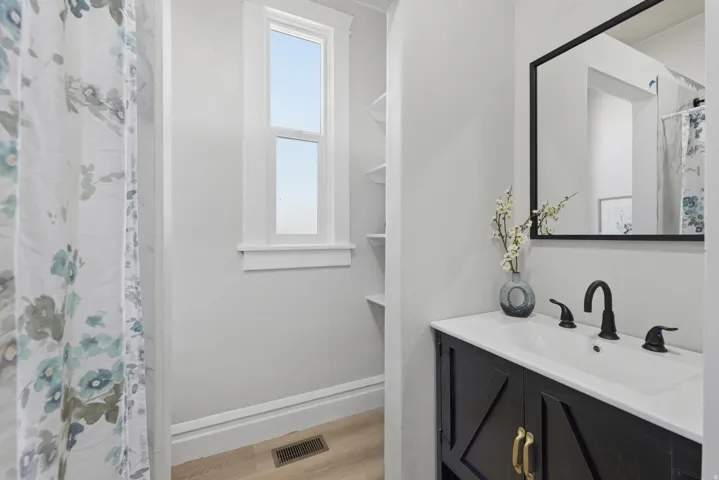 Bathroom featuring a black vanity with a white countertop, inset sink, and matte black faucet