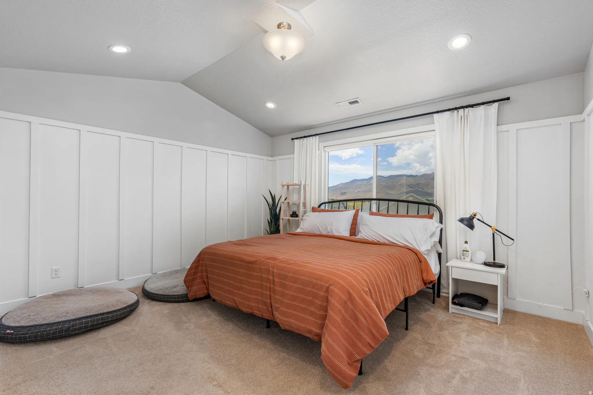 Carpeted bedroom featuring a vaulted ceiling with recessed lighting and a central ceiling fan