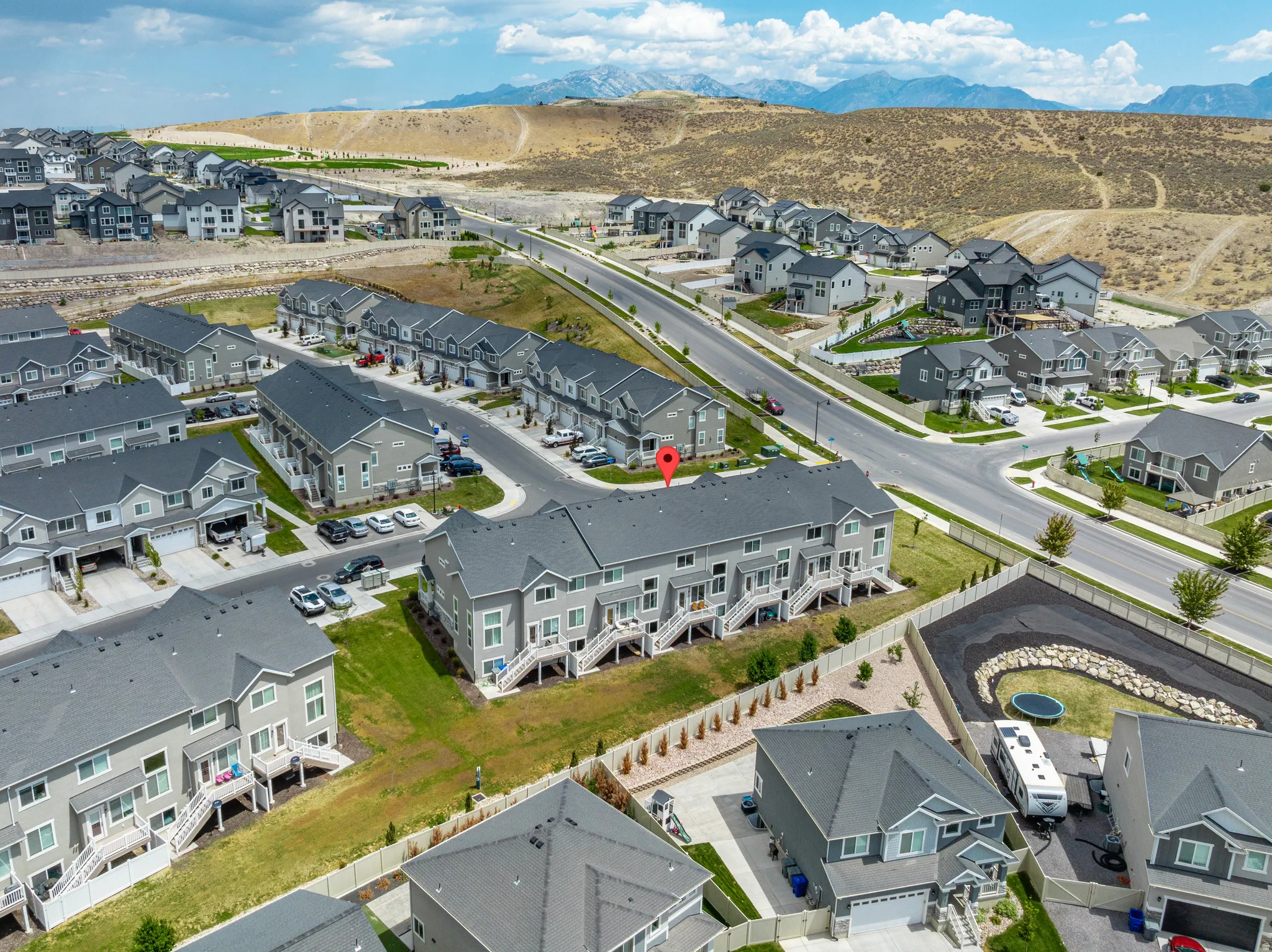 Townhome property featuring a grey exterior, private patios, and a mountain backdrop