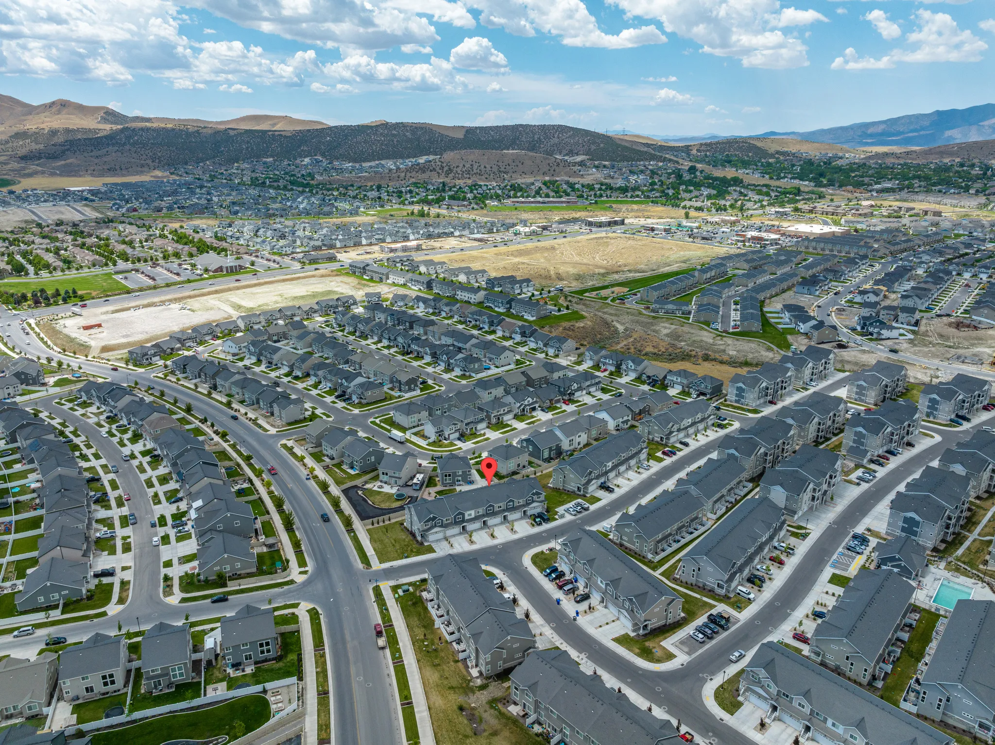 Aerial perspective of a developed residential community featuring rows of contemporary homes and townhomes