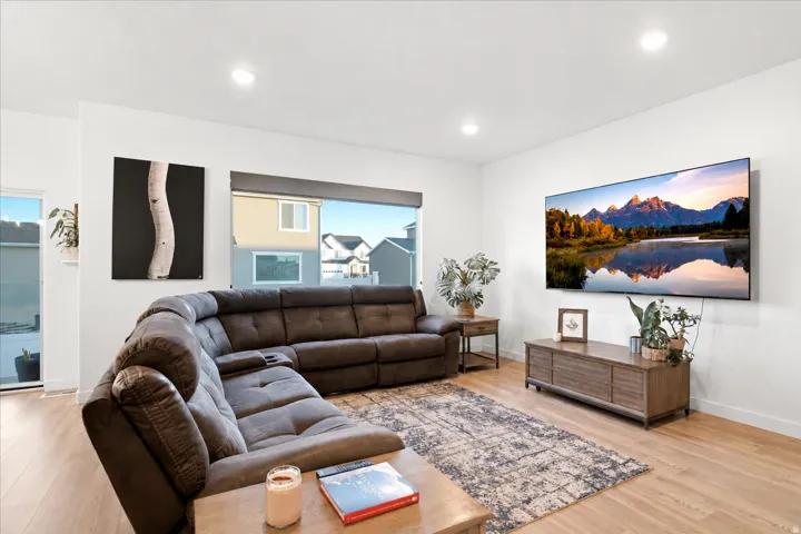 Open living area featuring wood-finish flooring, recessed lighting, and large windows