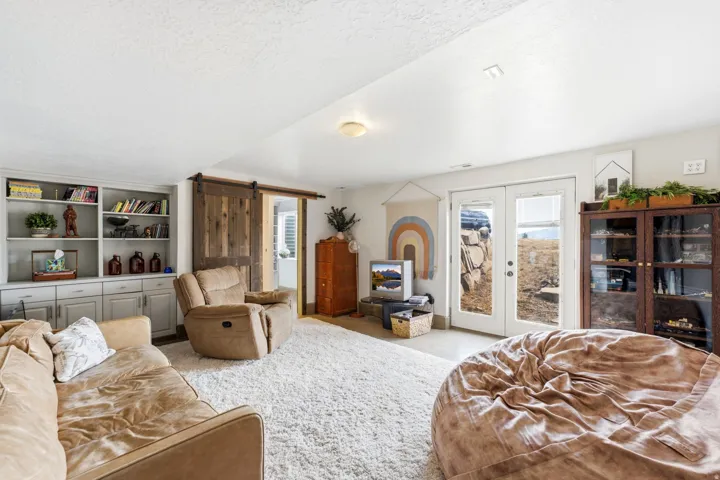 Spacious living area featuring light-toned carpeting and recessed lighting