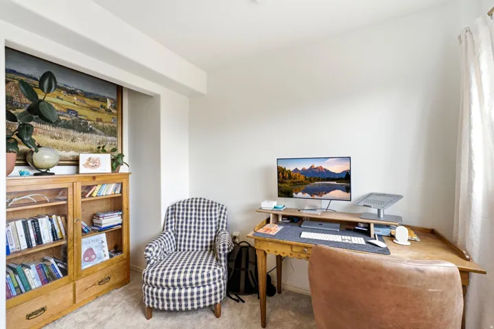 Recessed wall niche, light-colored carpeting, and window with sheer drapery