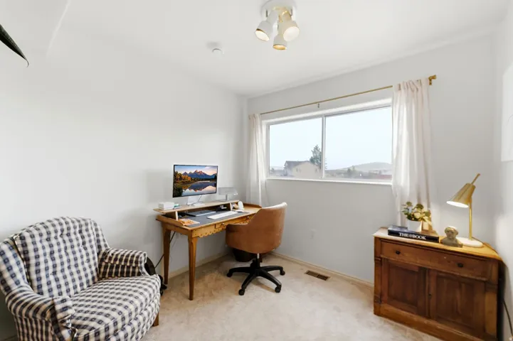 Bright room with neutral wall paint and carpeted flooring