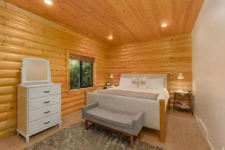 Wood-paneled walls and ceiling, updated carpet, recessed lighting, window with wood trim and a gorgeous view.