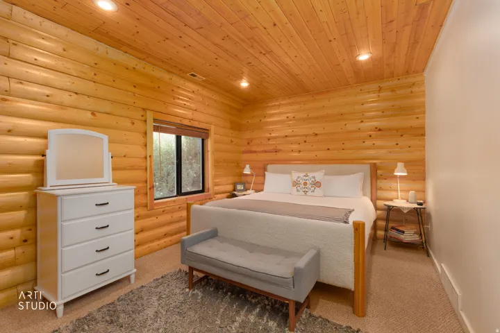 Wood-paneled walls and ceiling, updated carpet, recessed lighting, window with wood trim and a gorgeous view.
