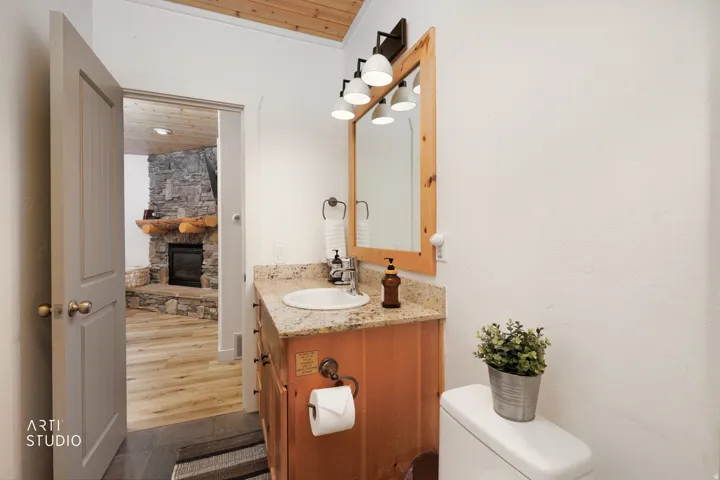 Completely updated bathroom featuring a a vanity, with granite countertop, under mount sink, and wood-finish cabinetry.