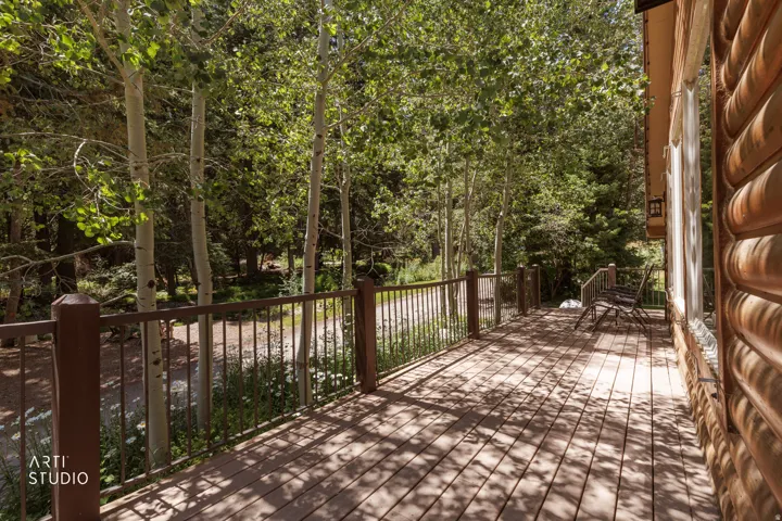 Expansive outdoor deck featuring wood-finish flooring and a metal railing