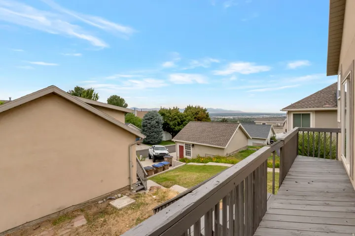 Elevated wood-plank deck with wood railing, offering expansive distant scenery