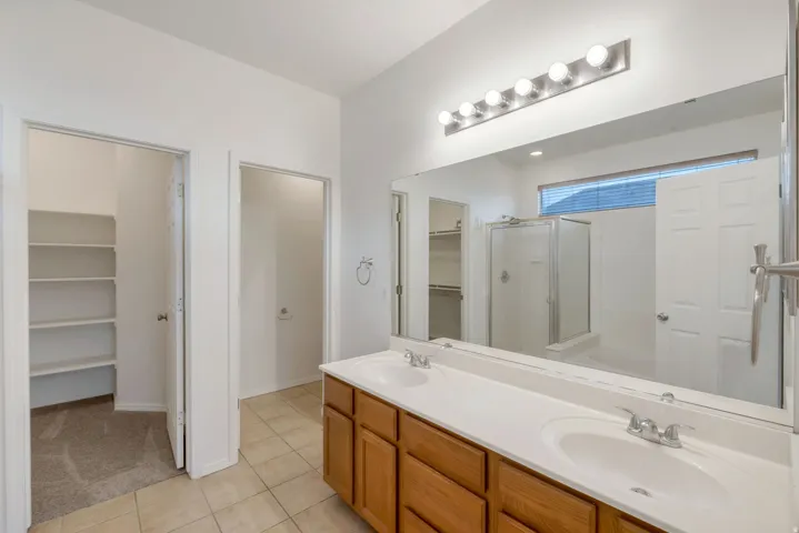 Double vanity with white countertops and wood cabinetry