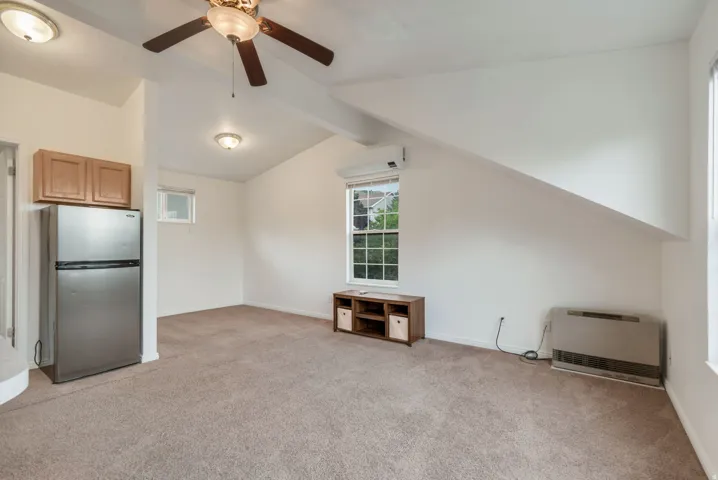 Carpeted room with a vaulted ceiling, recessed lighting, and a ceiling fan