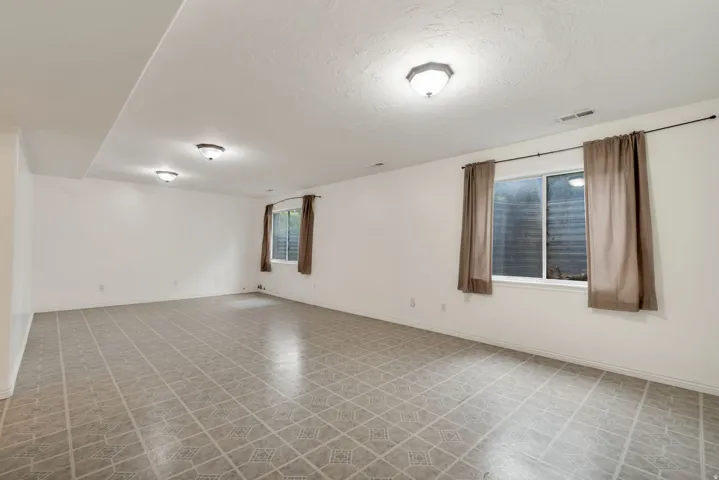 Expansive room featuring patterned tile flooring and white walls