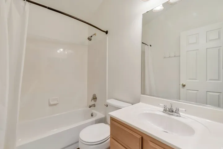 Bathroom featuring a white bathtub and shower combination with brushed nickel fixtures
