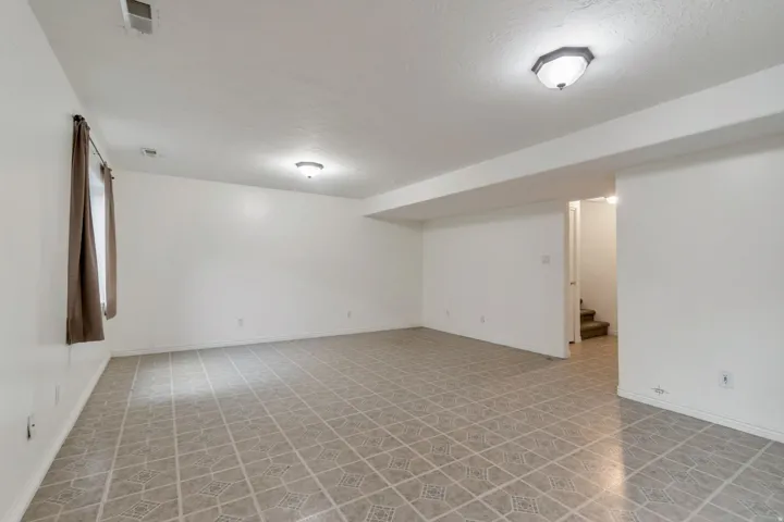 Spacious room featuring patterned tile flooring, neutral wall tones, and recessed ceiling lighting