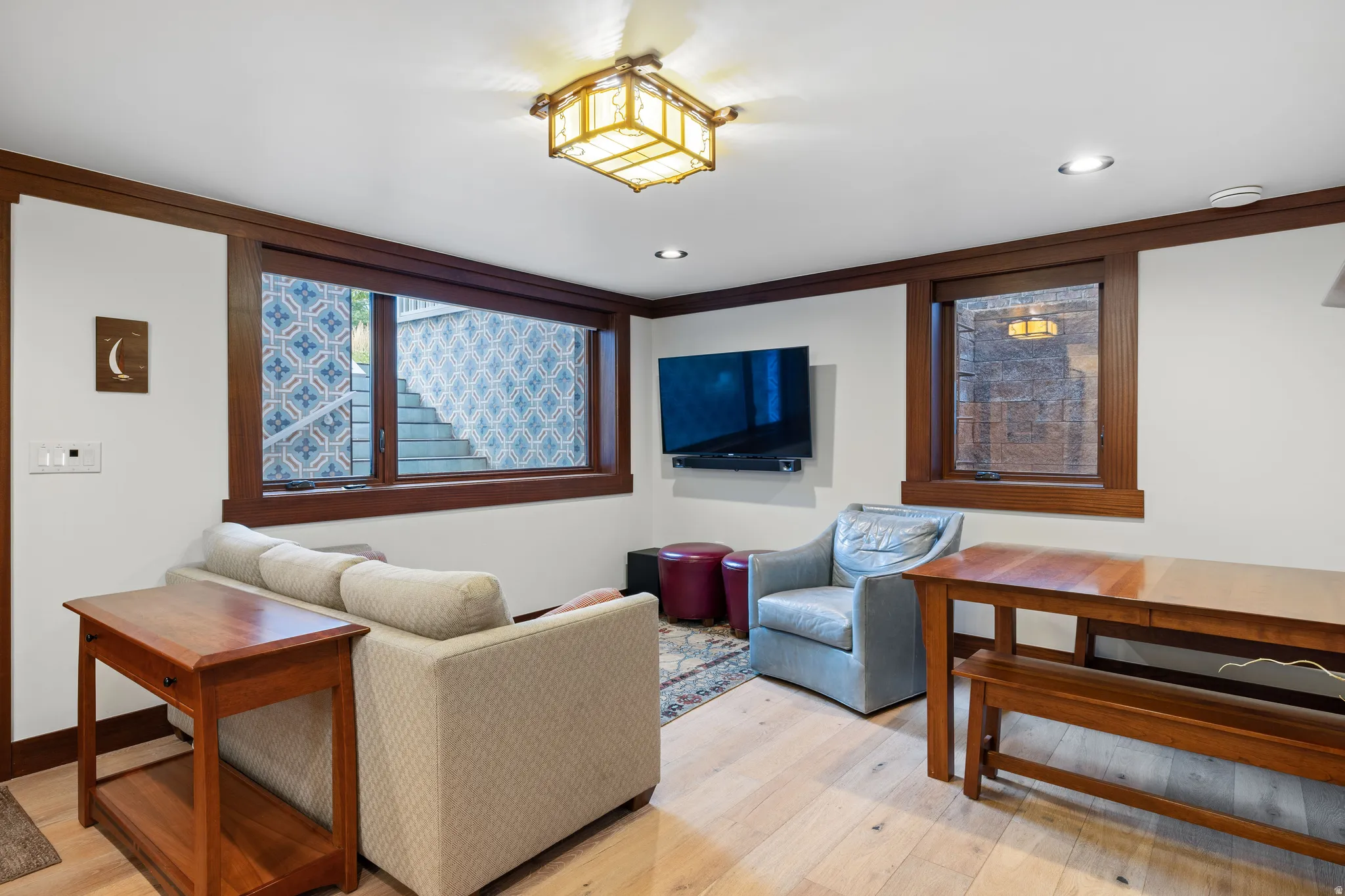 Bright living area featuring light wood-finish flooring, recessed lighting, and a decorative ceiling fixture