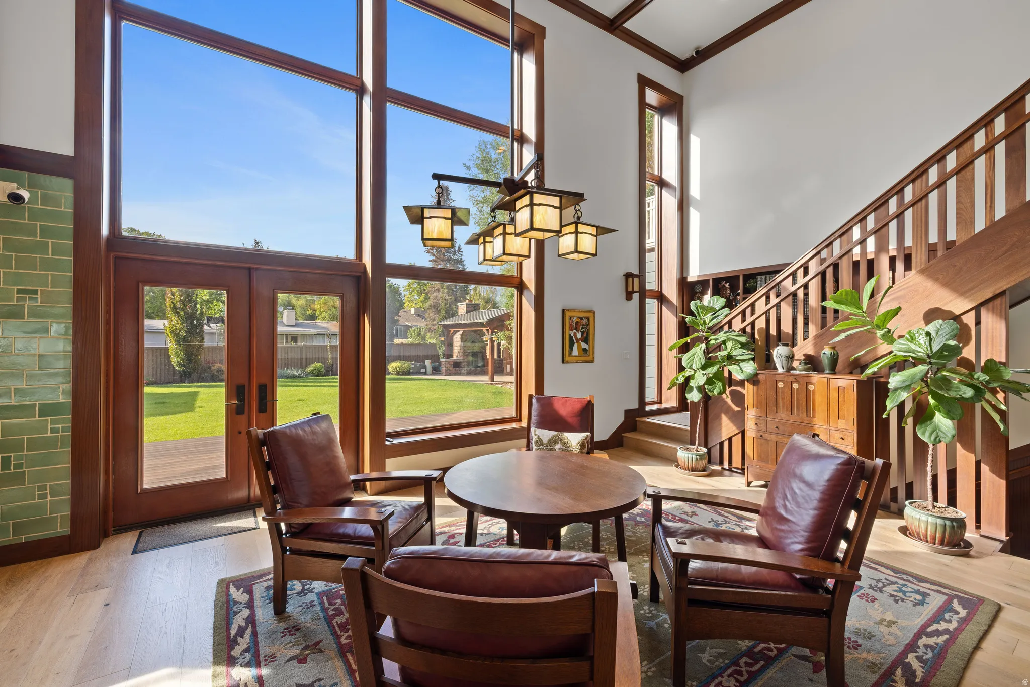 Two-story interior with prominent wood-finish staircase and expansive window wall