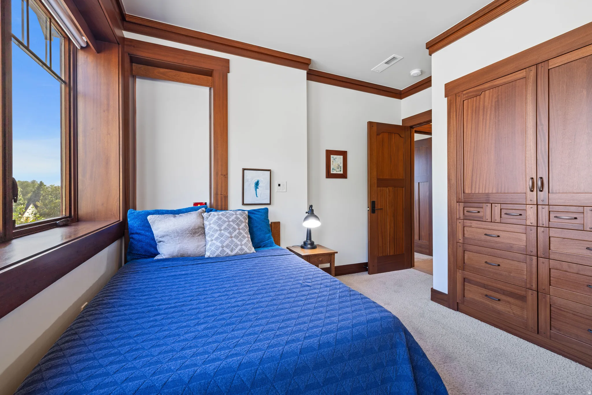 Bedroom with built-in wood cabinetry featuring multiple drawers and doors, complemented by matching wood trim and door frames