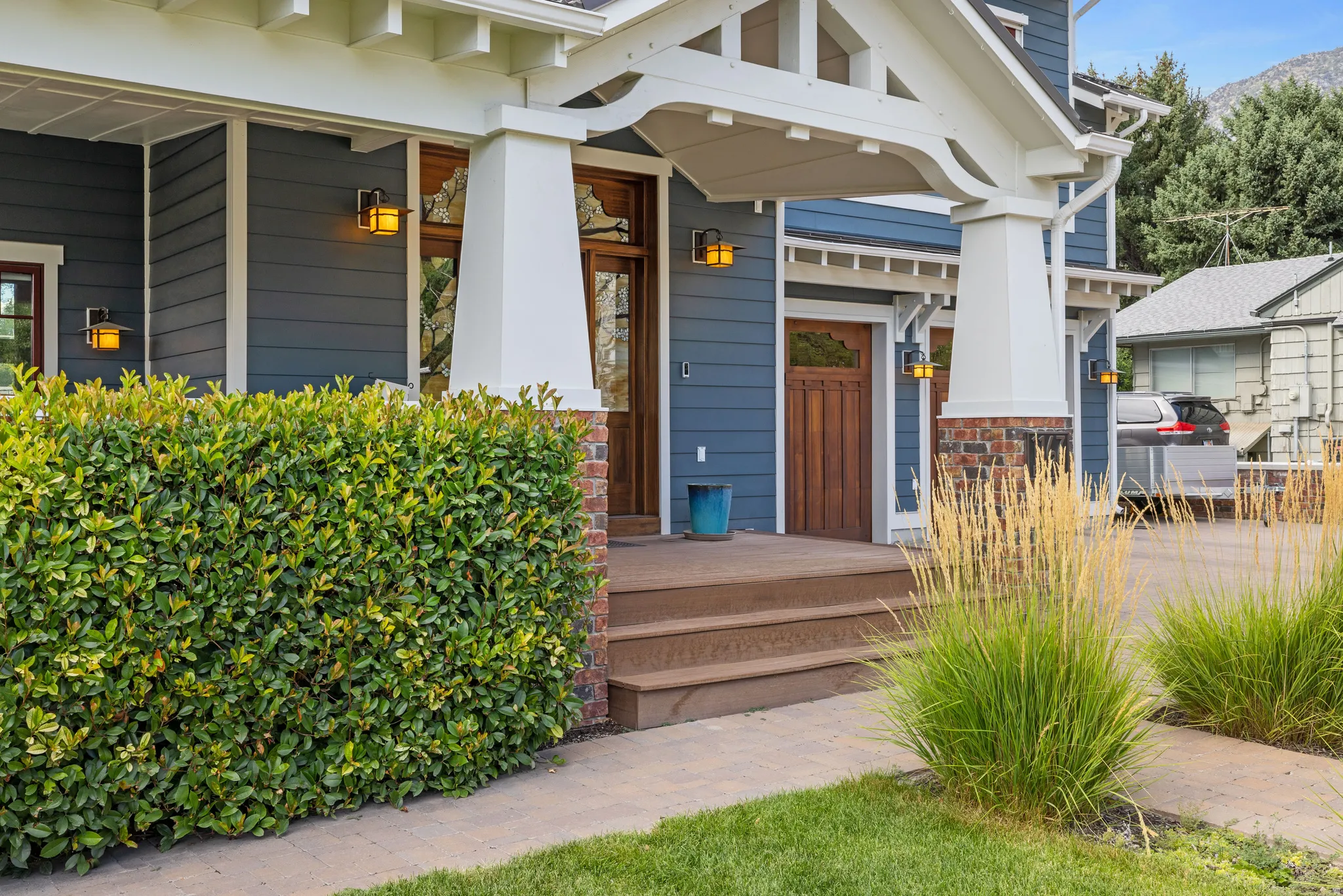 Craftsman-style exterior featuring blue horizontal siding, white trim, and a prominent front porch with decorative columns