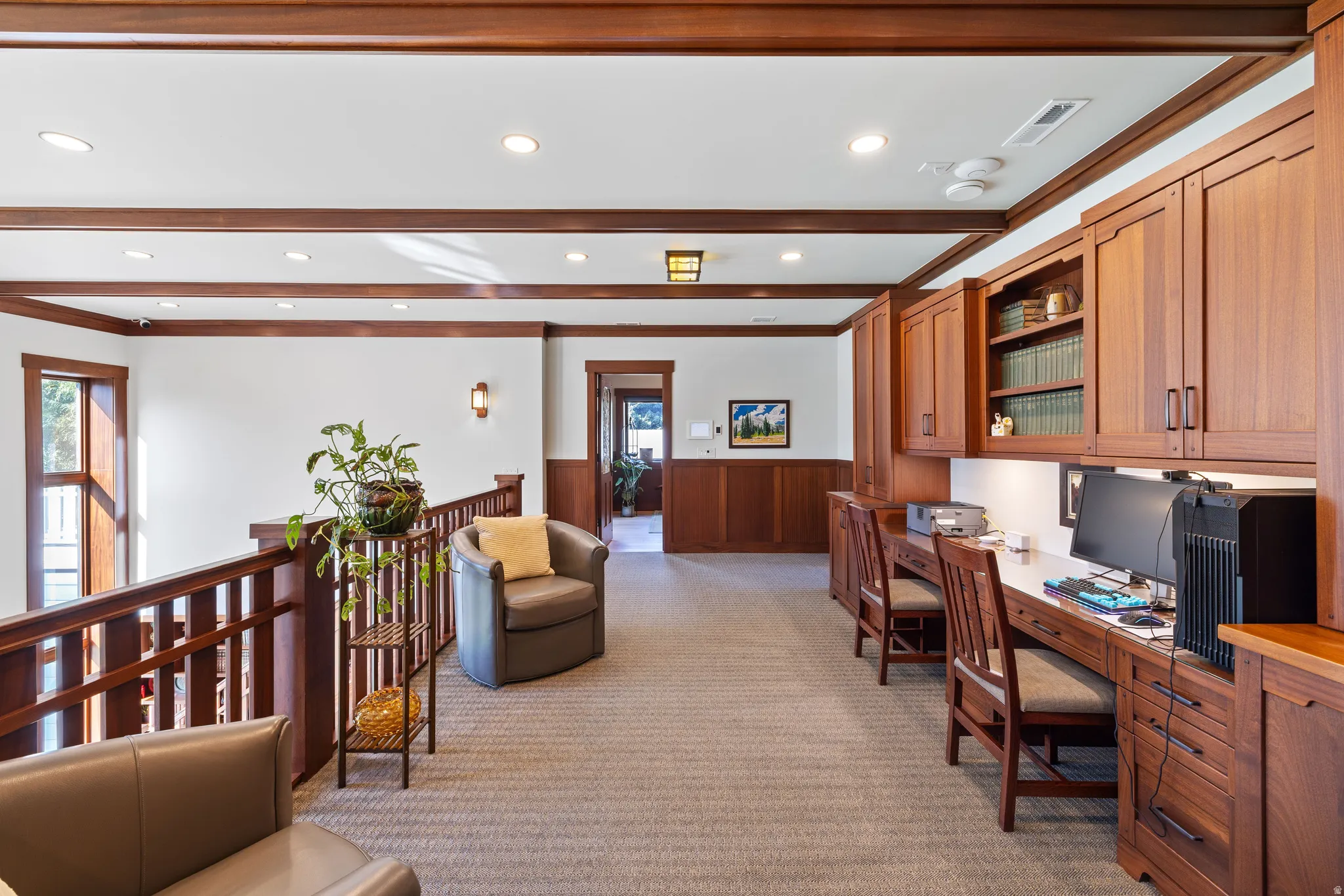 Upper level featuring built-in wood cabinetry, integrated desk spaces, and recessed lighting