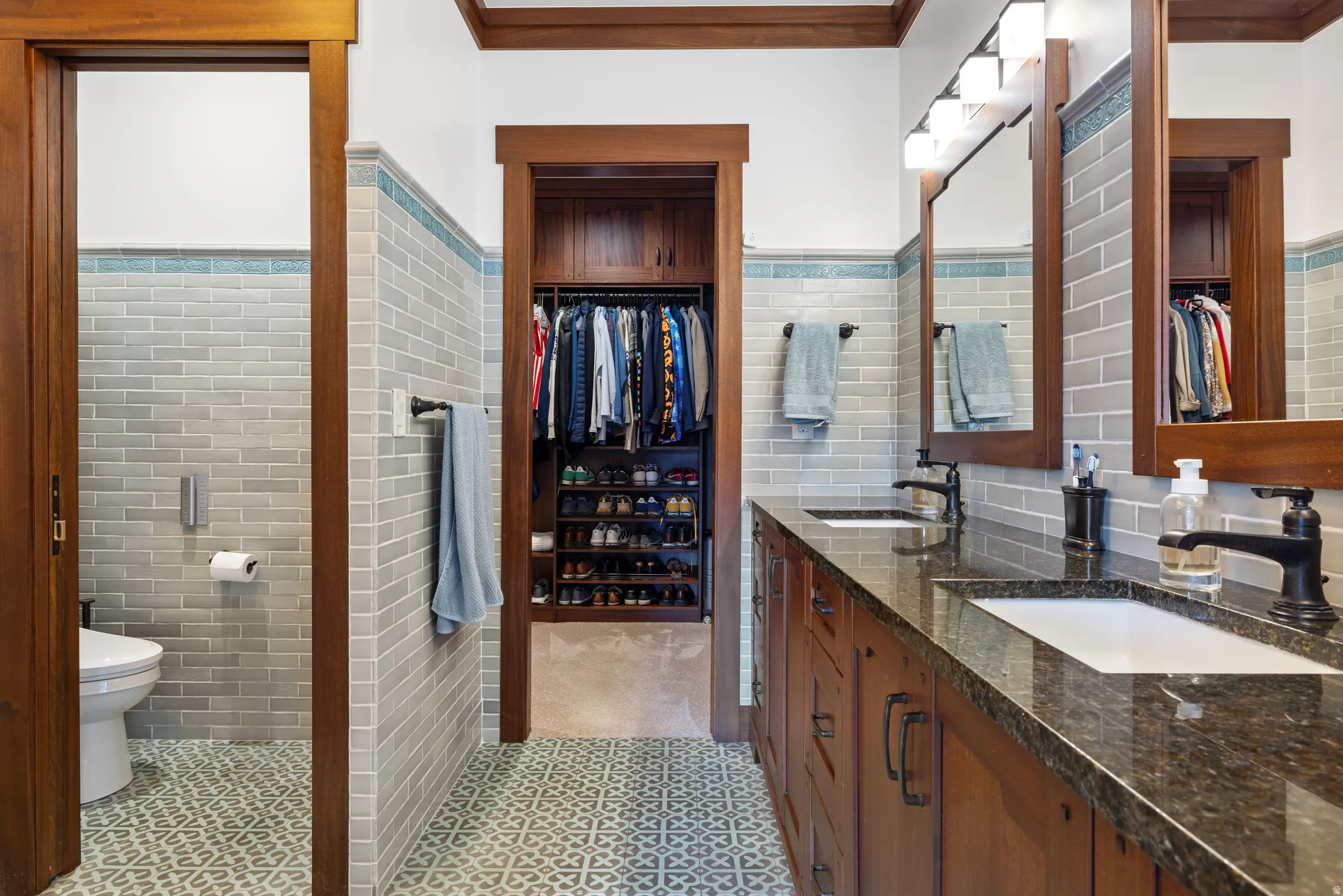 Dual vanity featuring undermount sinks and dark stone countertops