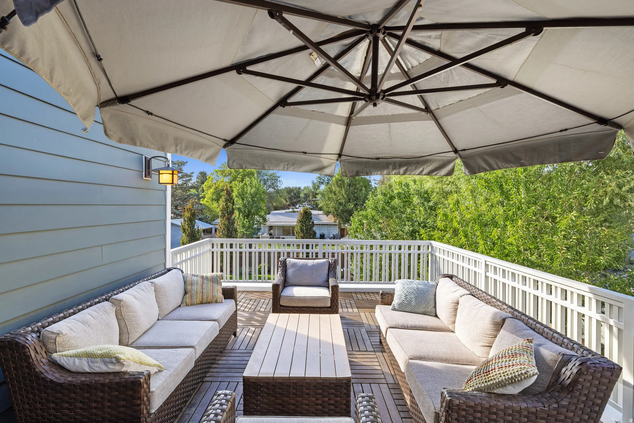 Rooftop deck just off the office featuring plank flooring, white railing, and a wall-mounted exterior light fixture