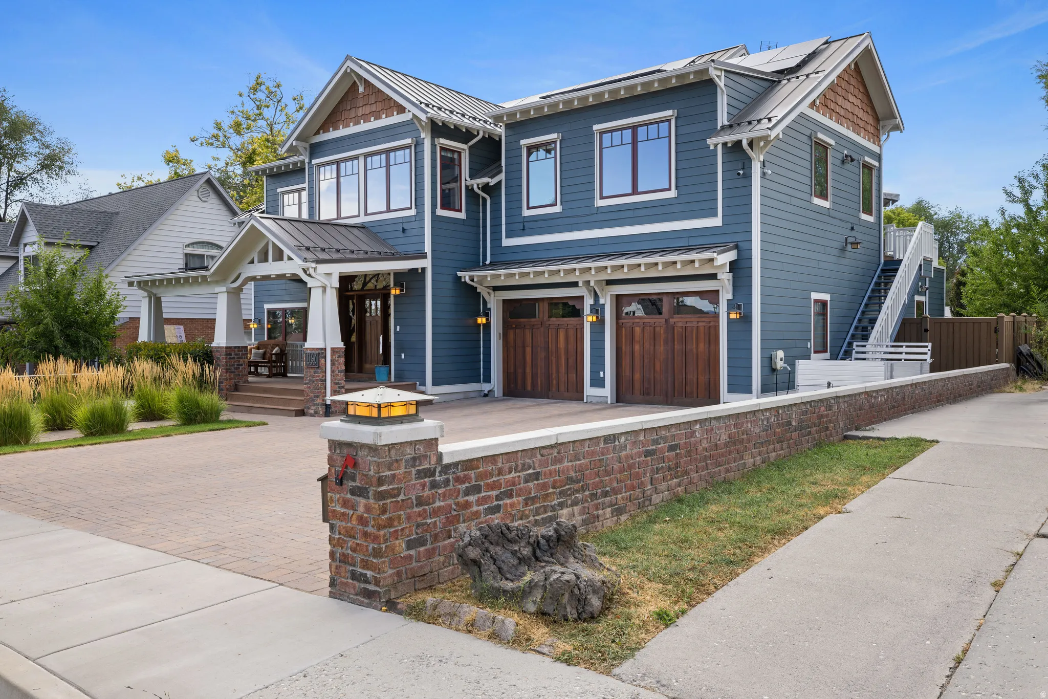 Contemporary two-story residence featuring blue siding, white trim, and a prominent covered entry