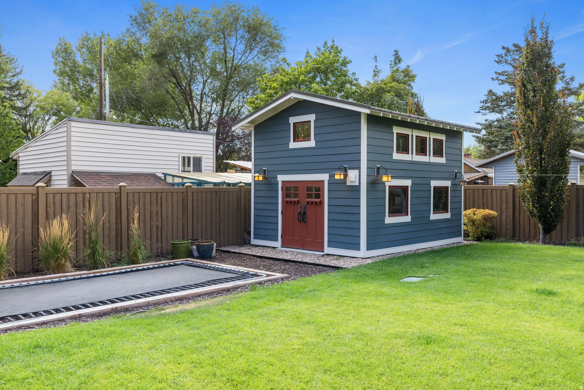 Two-story outbuilding with blue siding and contrasting red double doors