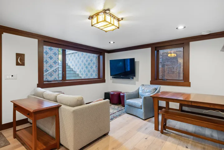 Bright living area featuring light wood-finish flooring, recessed lighting, and a decorative ceiling fixture