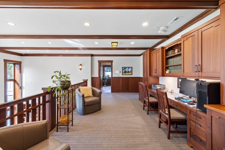 Upper level featuring built-in wood cabinetry, integrated desk spaces, and recessed lighting