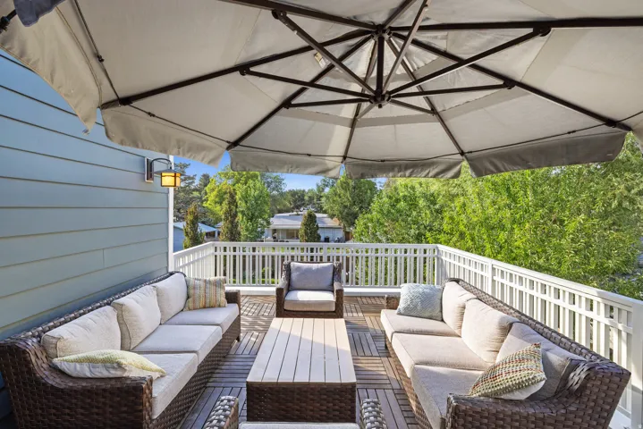 Rooftop deck just off the office featuring plank flooring, white railing, and a wall-mounted exterior light fixture
