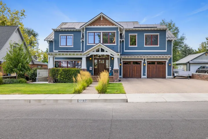 Craftsman-style home featuring a striking blue exterior with white trim