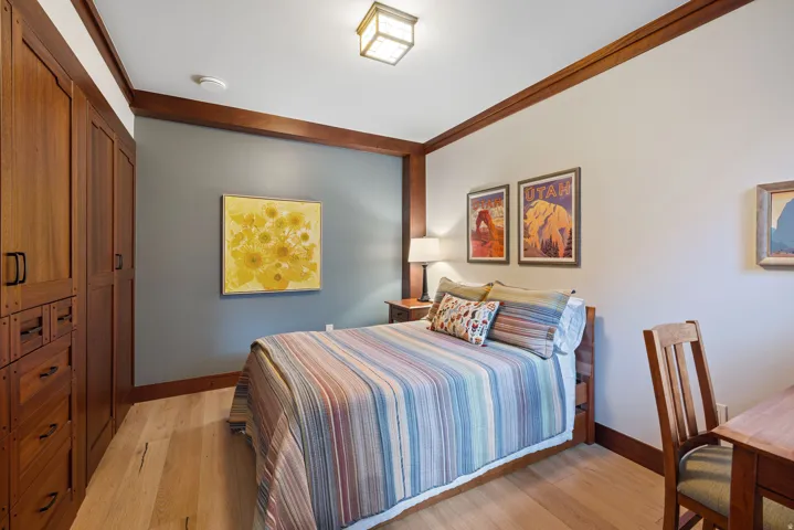 Warm wood-finish flooring complements custom built-in cabinetry and contrasting wall paneling