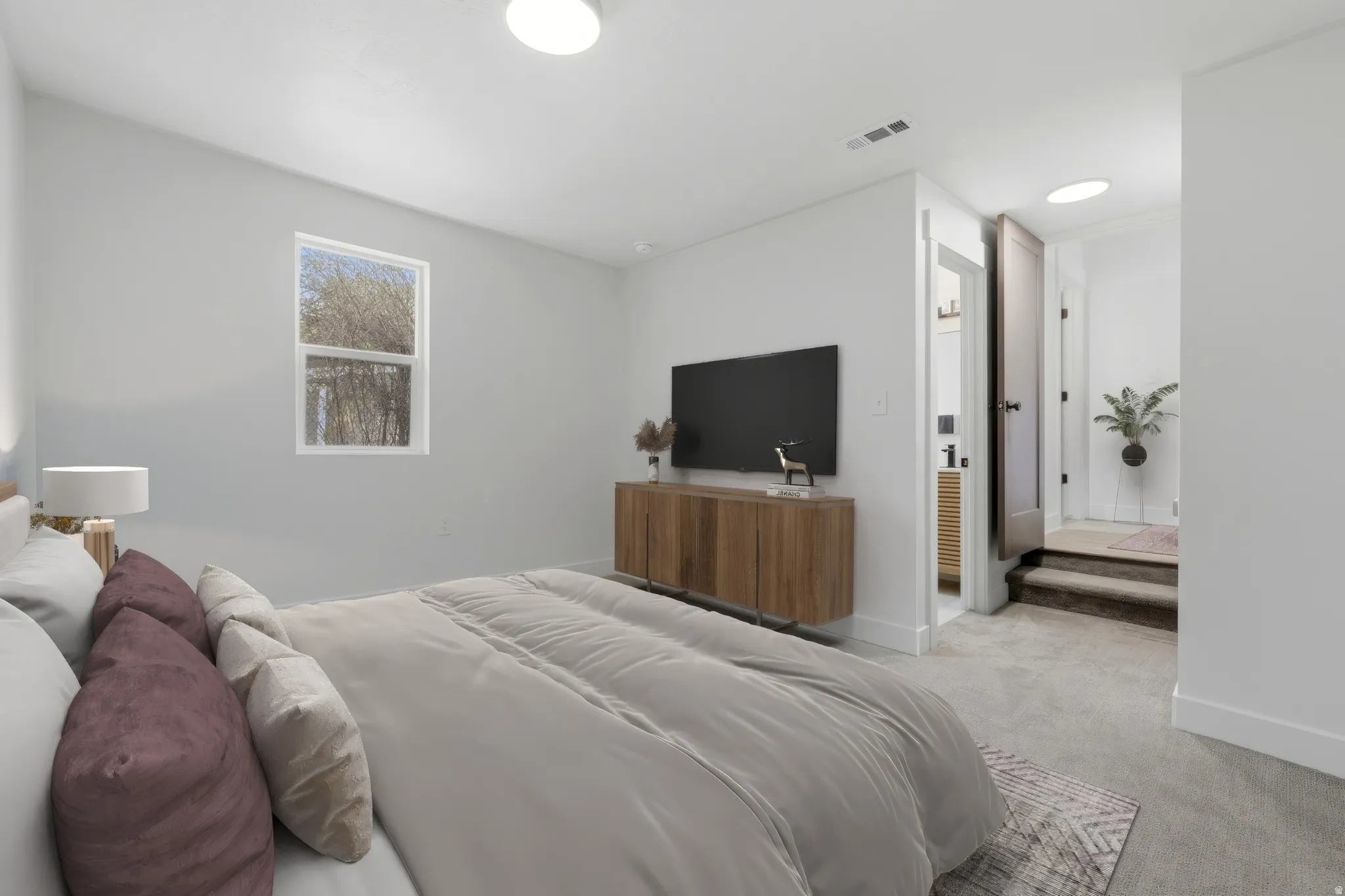 Carpeted room featuring a white single-hung window, white walls, and a recessed ceiling light