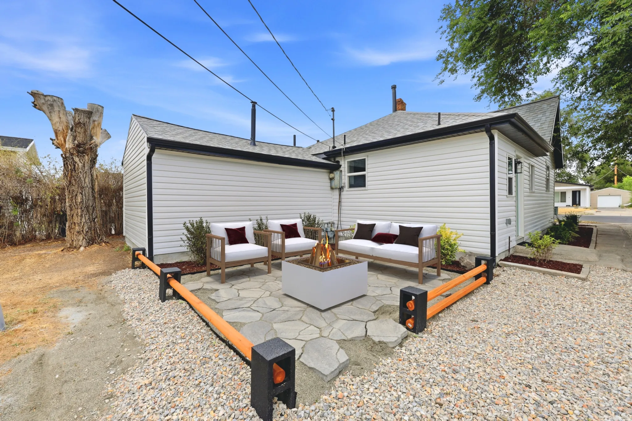 Outdoor patio featuring irregular flagstone pavers, a contemporary fire pit, and gravel landscaping