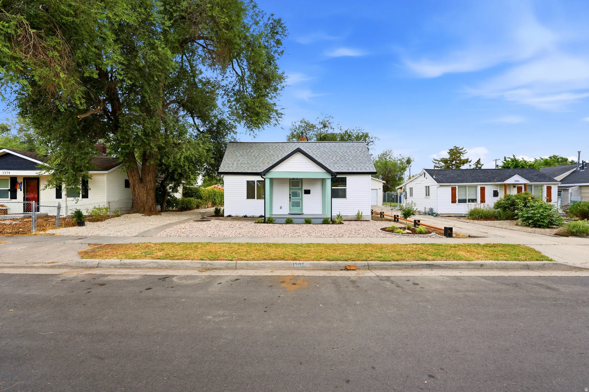 White exterior with a light teal front porch and dark gray roof