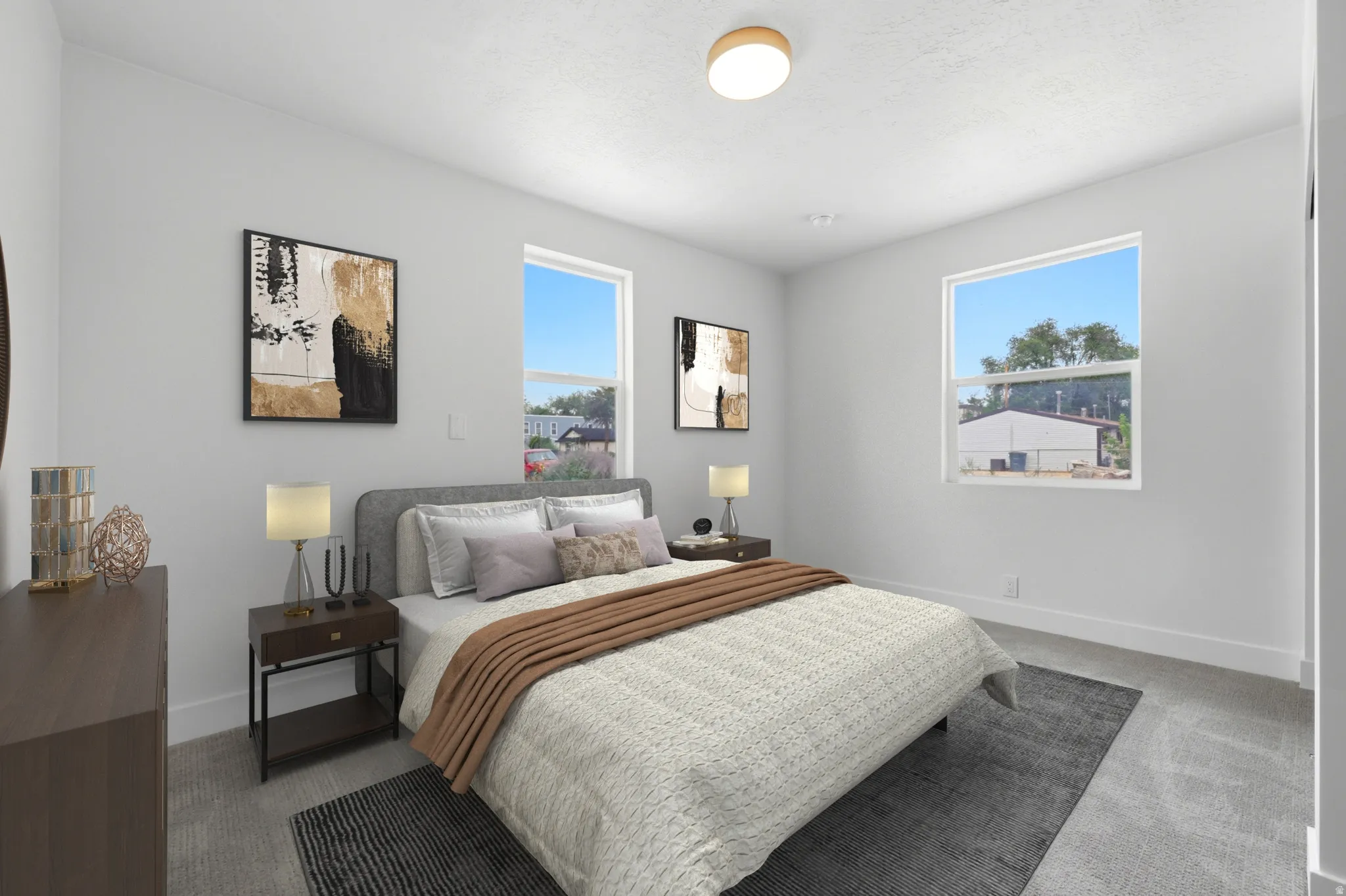 Spacious bedroom featuring light-colored walls, carpeted flooring, and two large windows providing ample natural light