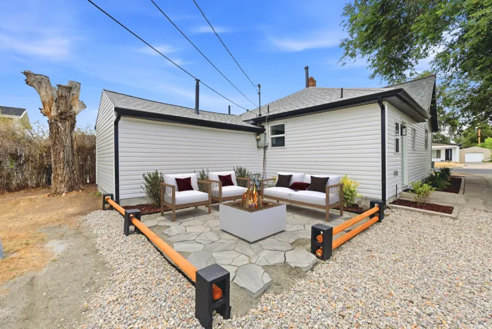 Outdoor patio featuring irregular flagstone pavers, a contemporary fire pit, and gravel landscaping