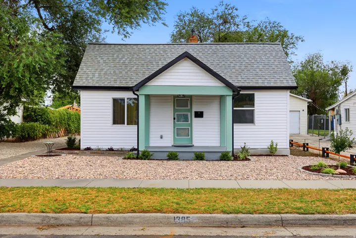 White siding exterior with a light green front door and porch columns