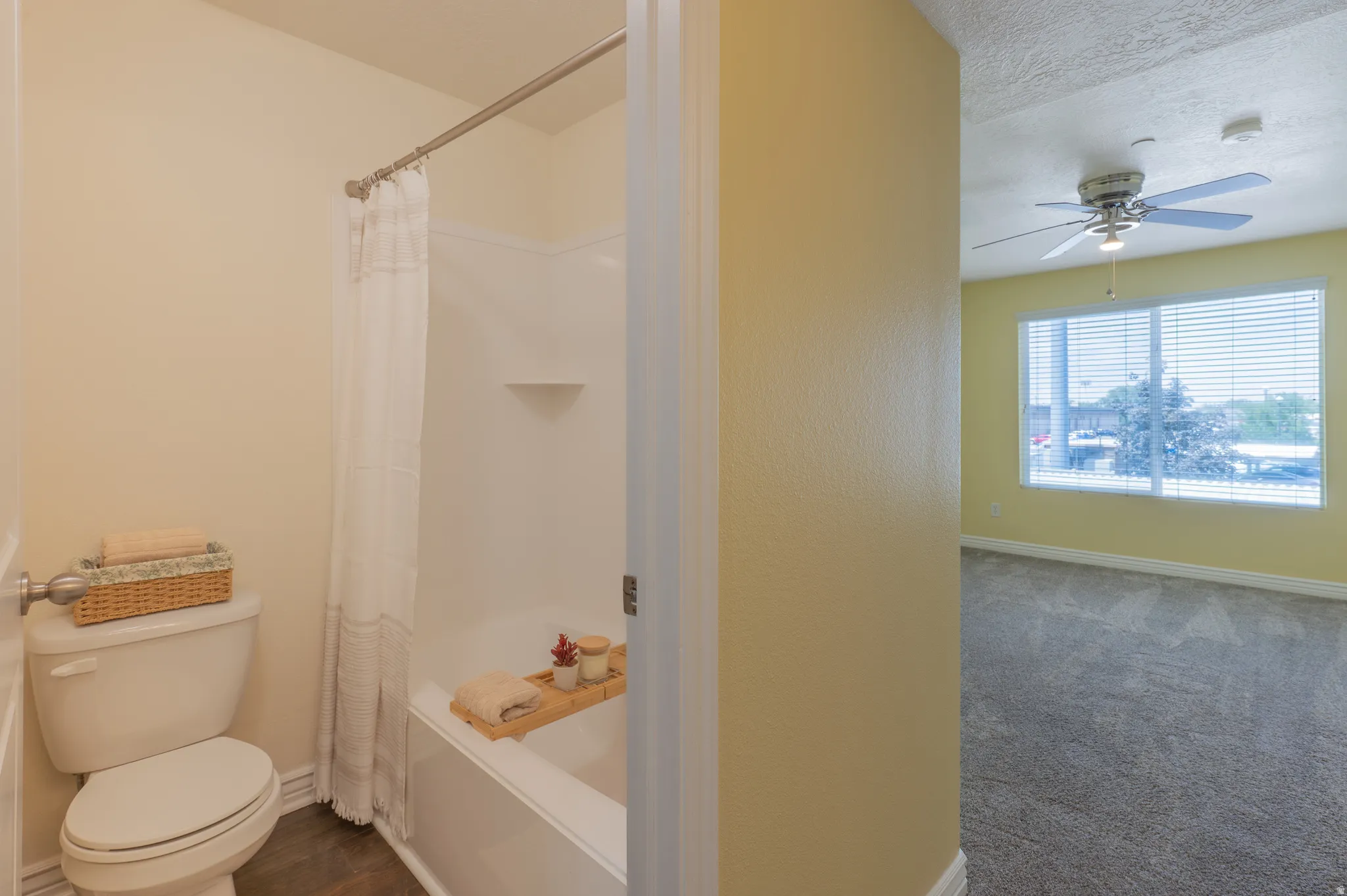 Full bathroom featuring a white tub and shower combination with a curved shower rod, and a white toilet