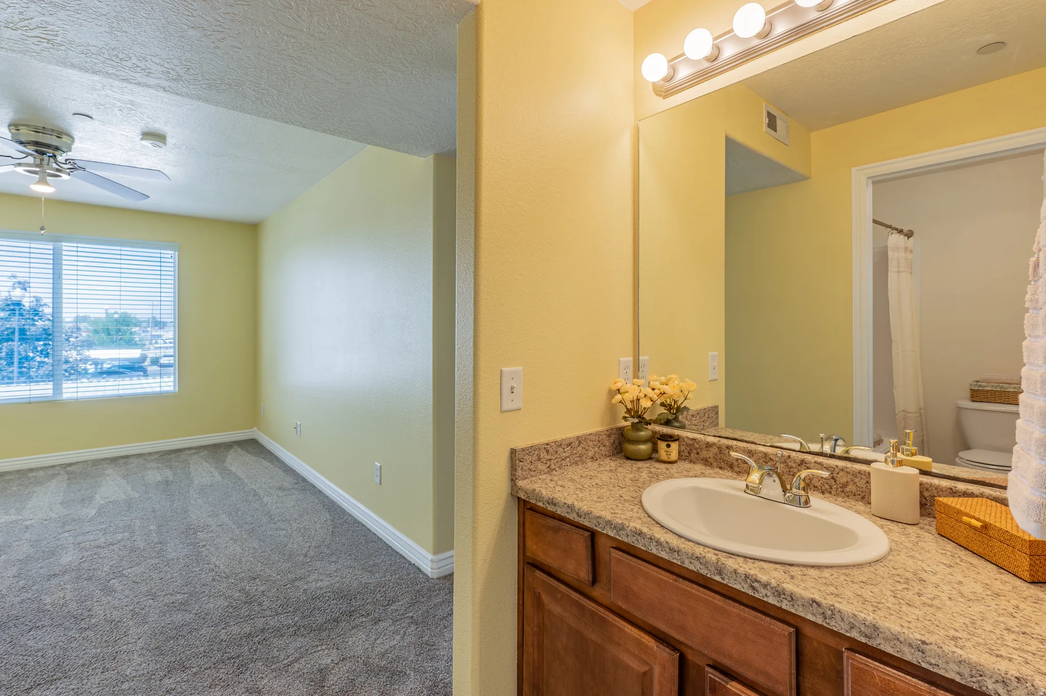 Bathroom vanity featuring a speckled countertop, integrated sink, and wood-finish cabinetry
