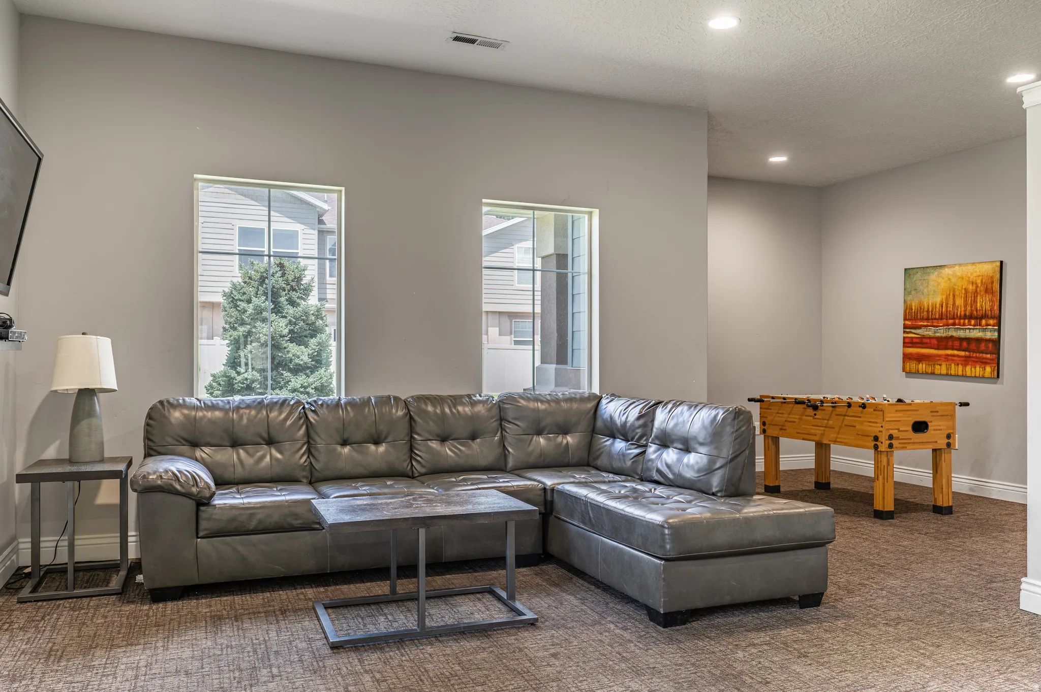 Recreation room featuring light gray walls, recessed lighting, and two windows