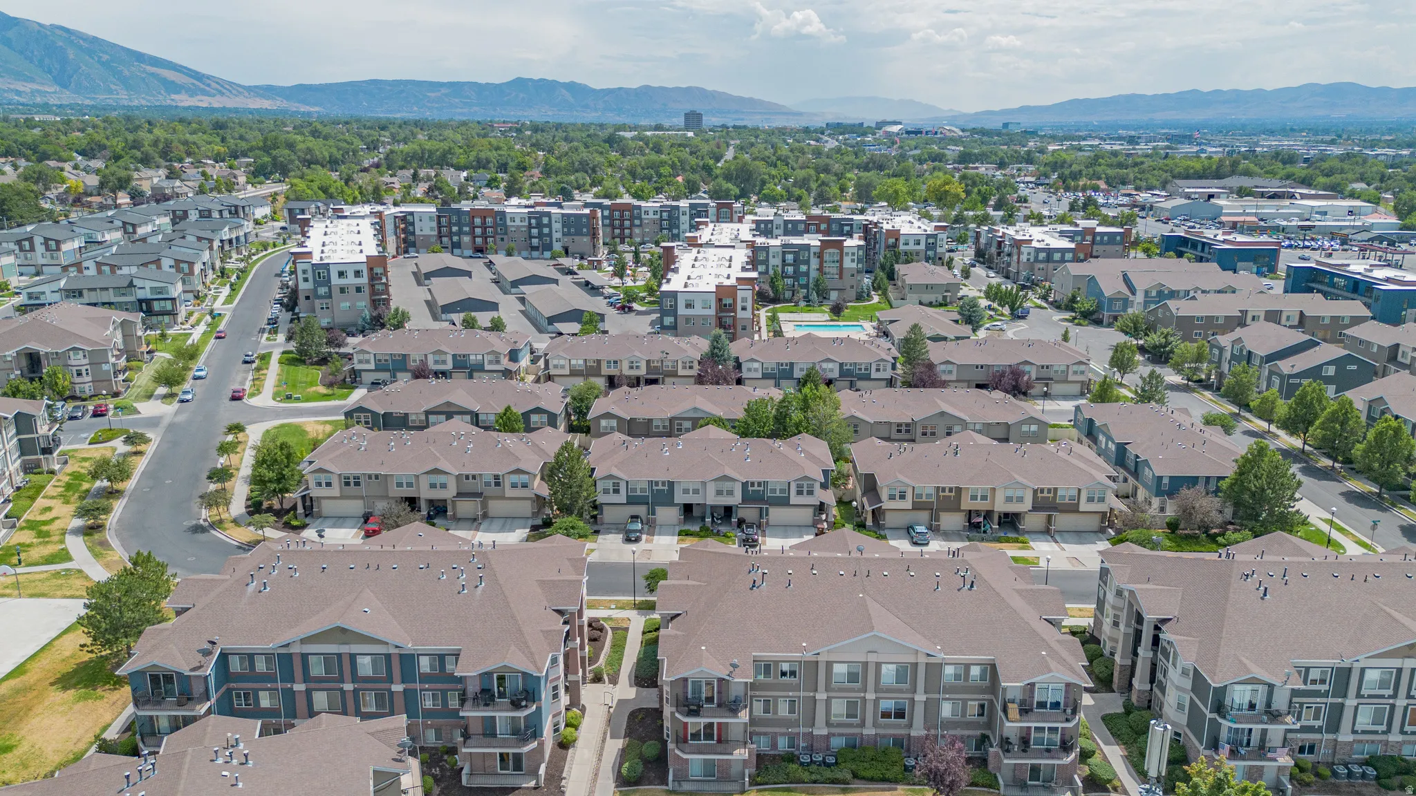Expansive residential community featuring diverse multi-story buildings with pitched roofs, balconies, and garages
